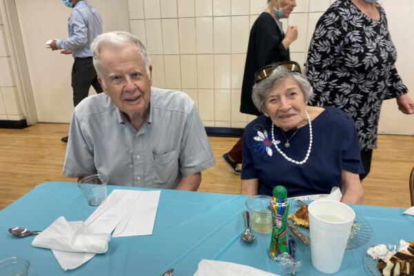 Senior man and woman sitting at the table during Feast Day of Saint Dominic de Guzman at St. Dominic Village.